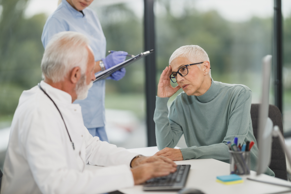 A doctor listening to a patient during a consultation in a bright clinical room